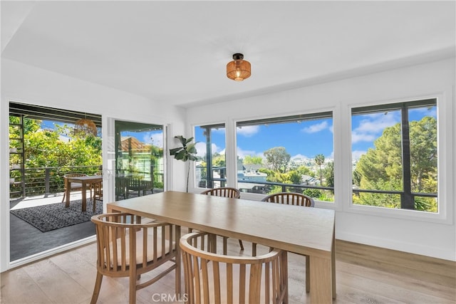 dining area with baseboards and light wood-style flooring