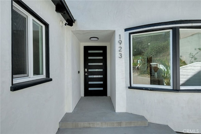 view of exterior entry with stucco siding