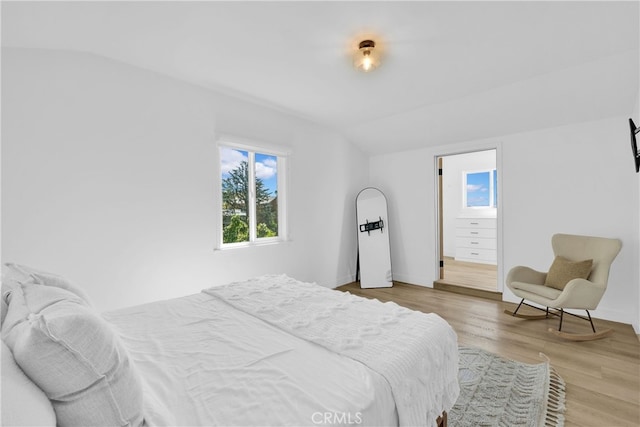 bedroom featuring light wood-type flooring and lofted ceiling