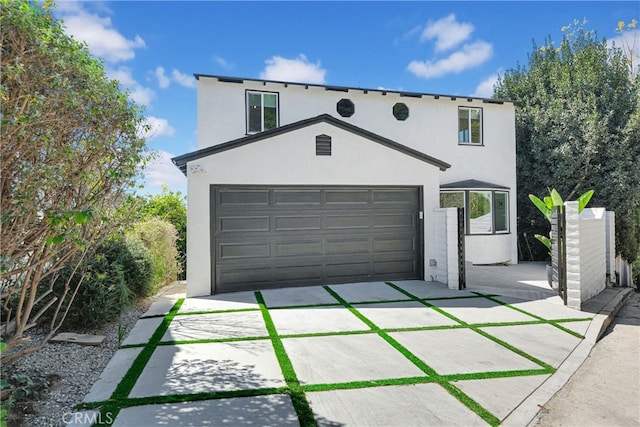 view of front of property with stucco siding, a garage, and concrete driveway