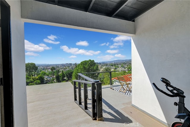 view of patio with a view of city and a balcony