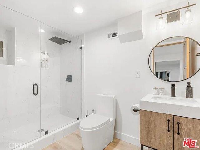 full bathroom with a marble finish shower, visible vents, and toilet