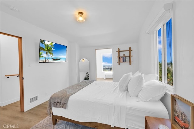 bedroom featuring light wood-type flooring, visible vents, and baseboards