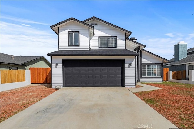 traditional-style home with driveway, a garage, and fence