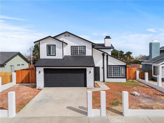 traditional-style house featuring a garage, roof with shingles, concrete driveway, and fence