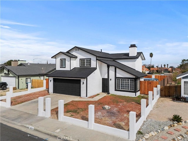 view of front of home featuring a chimney, concrete driveway, a garage, and fence