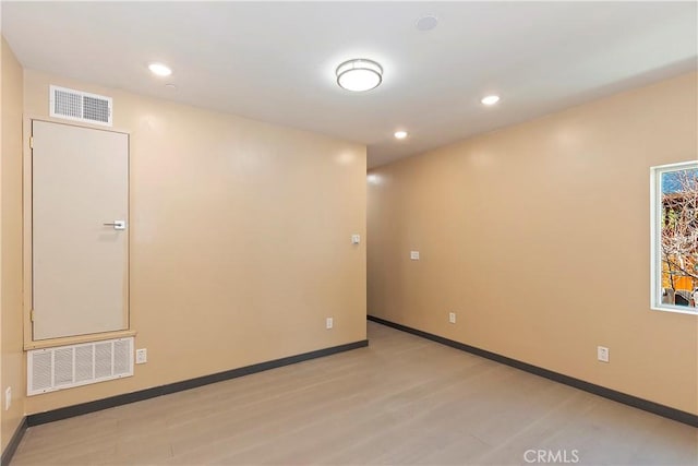 spare room with light wood-type flooring, visible vents, baseboards, and recessed lighting