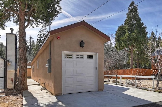 detached garage with driveway and fence