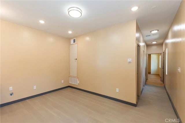 spare room with recessed lighting, visible vents, light wood-style flooring, and baseboards