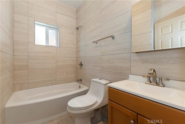 bathroom with vanity, tile walls, toilet, and  shower combination