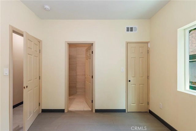 unfurnished bedroom featuring visible vents and baseboards