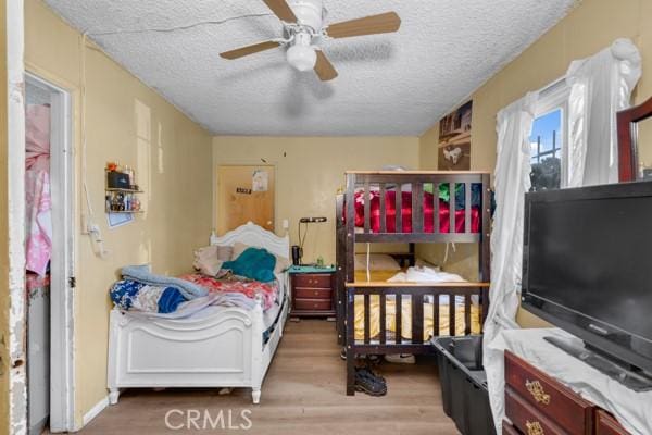 bedroom featuring a textured ceiling and wood finished floors