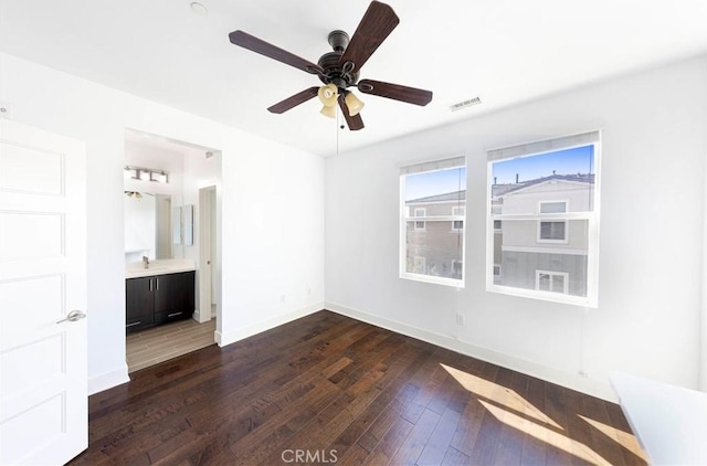 unfurnished bedroom with visible vents, baseboards, dark wood-style floors, and ensuite bathroom