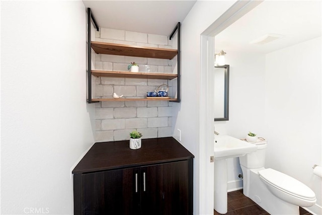 half bath featuring toilet and tasteful backsplash