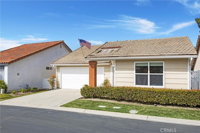 view of front of house with an attached garage, concrete driveway, and fence