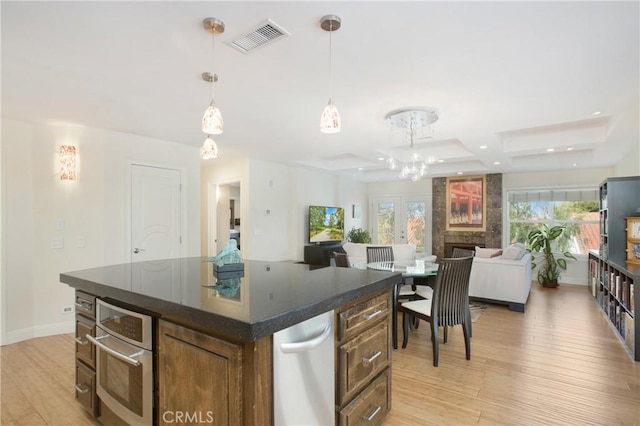 kitchen featuring oven, visible vents, dark countertops, and light wood finished floors