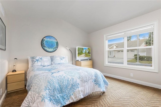 bedroom featuring baseboards and lofted ceiling