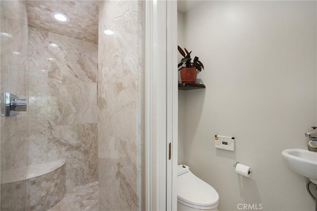 bathroom featuring toilet and tiled shower