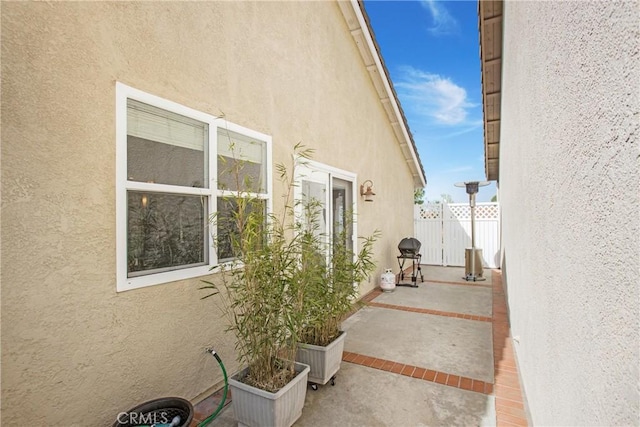 view of home's exterior featuring stucco siding, a patio, and fence