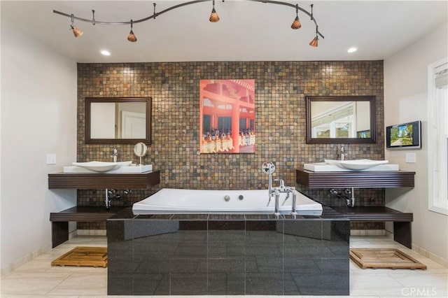 full bathroom with tile patterned floors, baseboards, a garden tub, and vanity