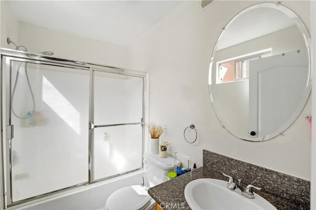 full bath featuring combined bath / shower with glass door, toilet, and vanity