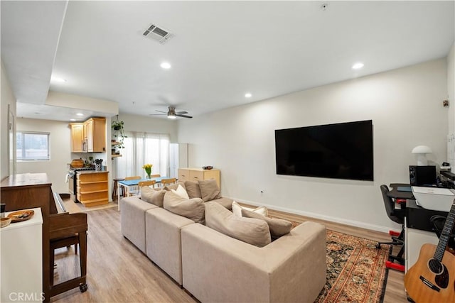 living room with recessed lighting, visible vents, plenty of natural light, and light wood-style flooring