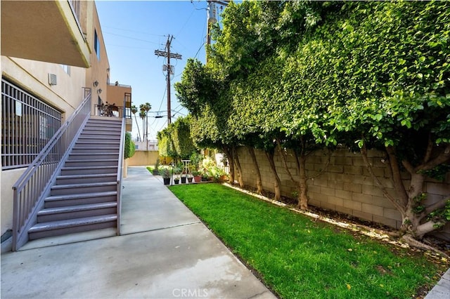 view of yard featuring stairs, a patio, and fence