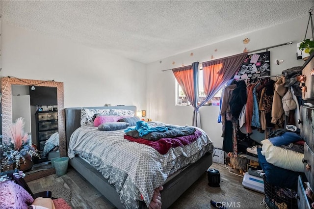 bedroom with a textured ceiling and wood finished floors