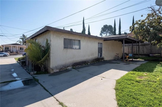 view of property exterior featuring stucco siding and fence