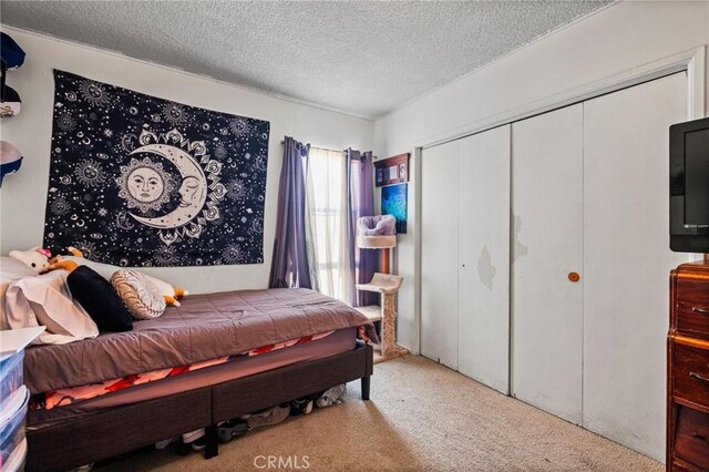 bedroom with a closet, carpet flooring, and a textured ceiling