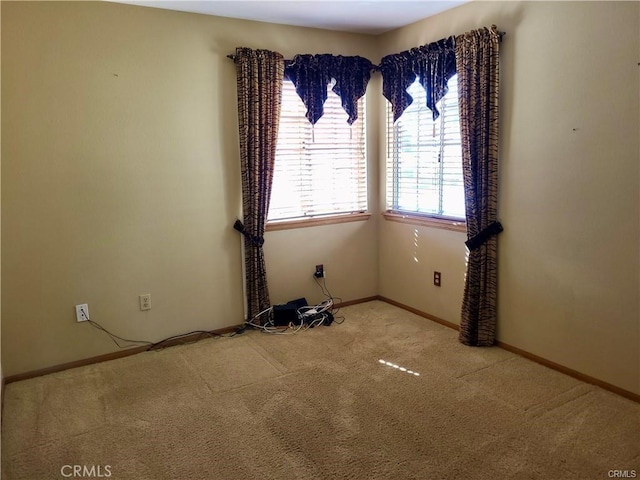 spare room featuring baseboards and carpet flooring