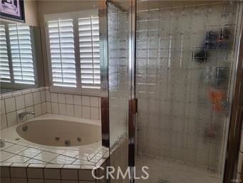 full bathroom featuring a shower stall and a tub with jets