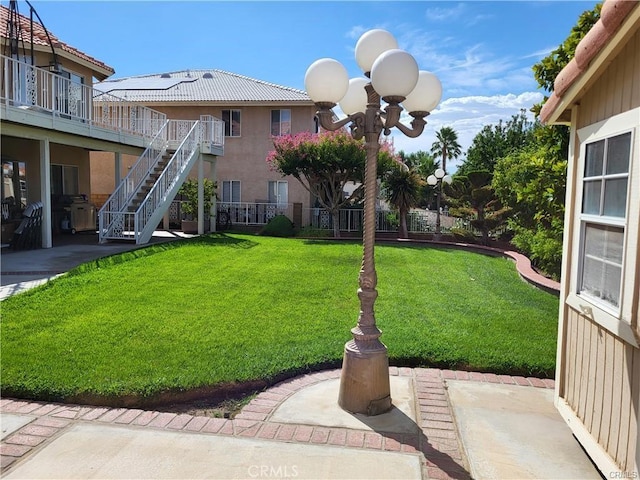 view of yard with a patio and stairs