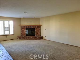 unfurnished living room with a fireplace and carpet floors