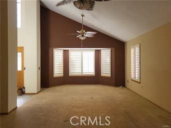 carpeted spare room featuring lofted ceiling and ceiling fan