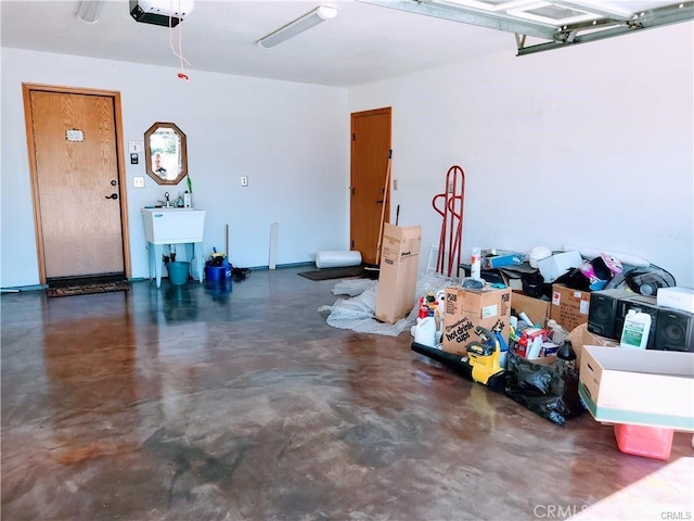 garage with a garage door opener and a sink