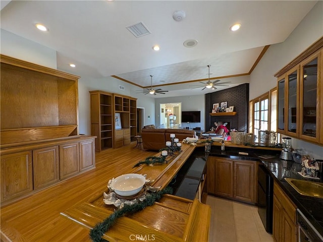 kitchen with dark countertops, visible vents, open floor plan, dishwashing machine, and a sink