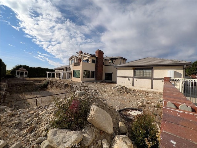 view of front facade featuring stucco siding and fence