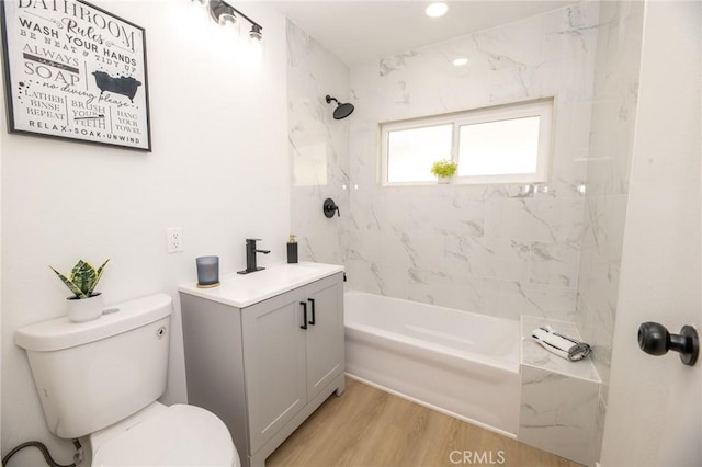 full bathroom featuring vanity, toilet, wood finished floors, and shower / bathtub combination