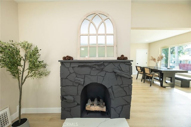 interior details with visible vents, a fireplace, baseboards, and wood finished floors