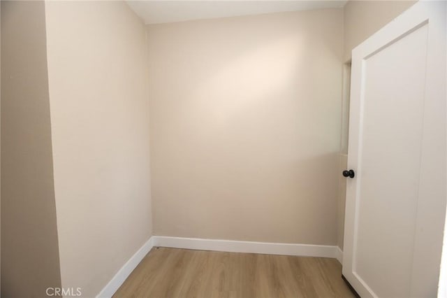 spare room featuring light wood-style flooring and baseboards