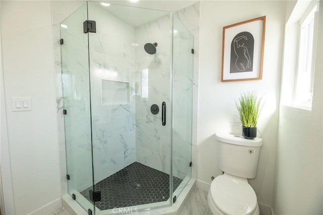 bathroom featuring toilet, plenty of natural light, and a marble finish shower