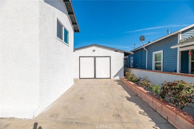 view of patio / terrace featuring an outbuilding, a storage unit, and fence