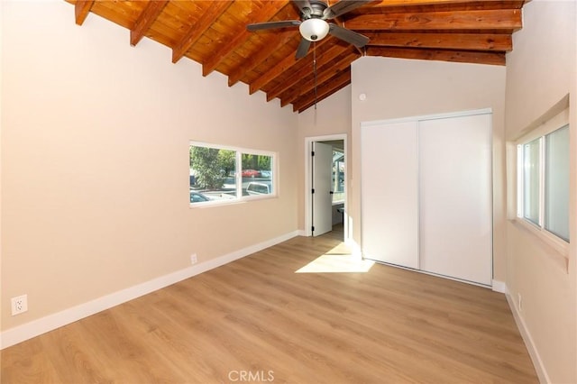 unfurnished bedroom featuring wooden ceiling, baseboards, light wood finished floors, and beam ceiling