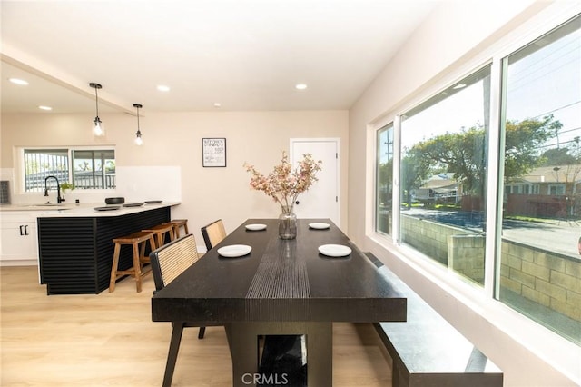 dining space with light wood finished floors and recessed lighting