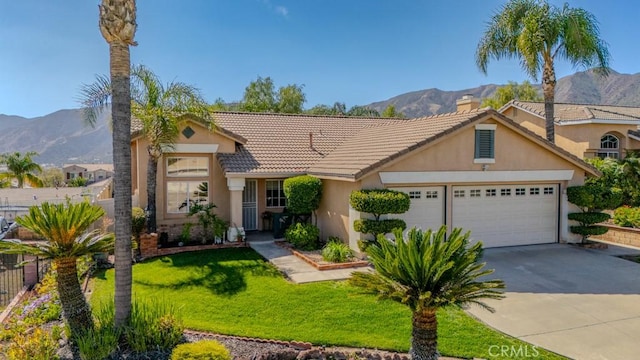 view of front of home with an attached garage, a mountain view, driveway, and stucco siding