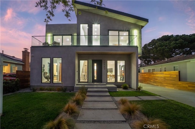 10943 Pickford Way, Culver City, CA 90230 - view of front of house featuring stucco siding, fence, a balcony, and a front yard