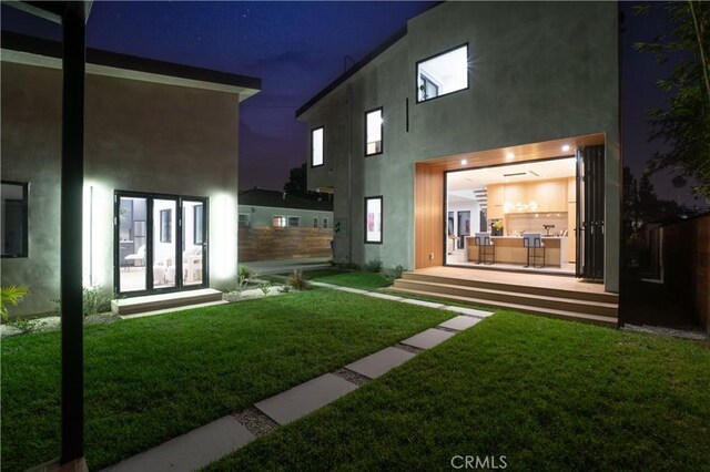 10943 Pickford Way, Culver City, CA 90230 - back of house at twilight featuring stucco siding and a yard