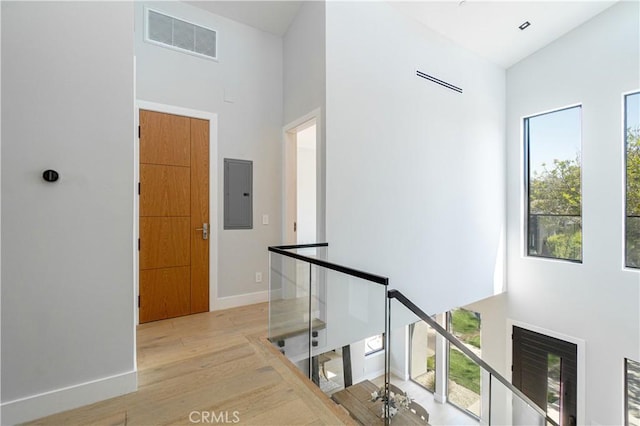 10943 Pickford Way, Culver City, CA 90230 - corridor featuring visible vents, wood finished floors, a high ceiling, electric panel, and an upstairs landing