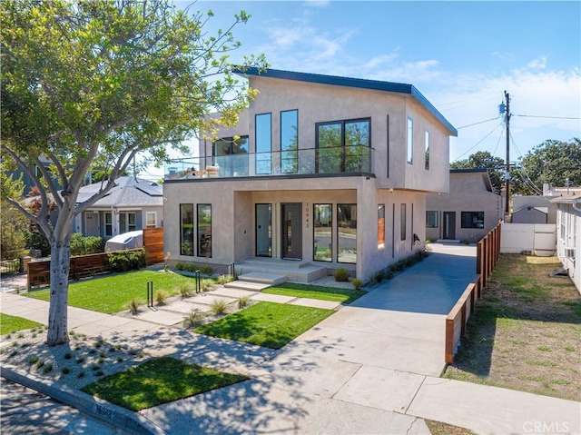 10943 Pickford Way, Culver City, CA 90230 - exterior space featuring fence, stucco siding, a balcony, a lawn, and driveway